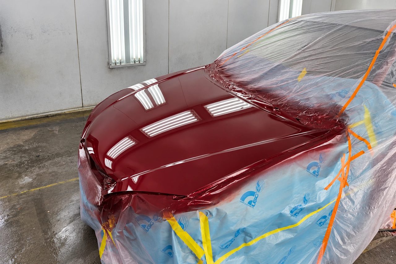 Fresh paint on a vehicle hood in J & J’s paint booth