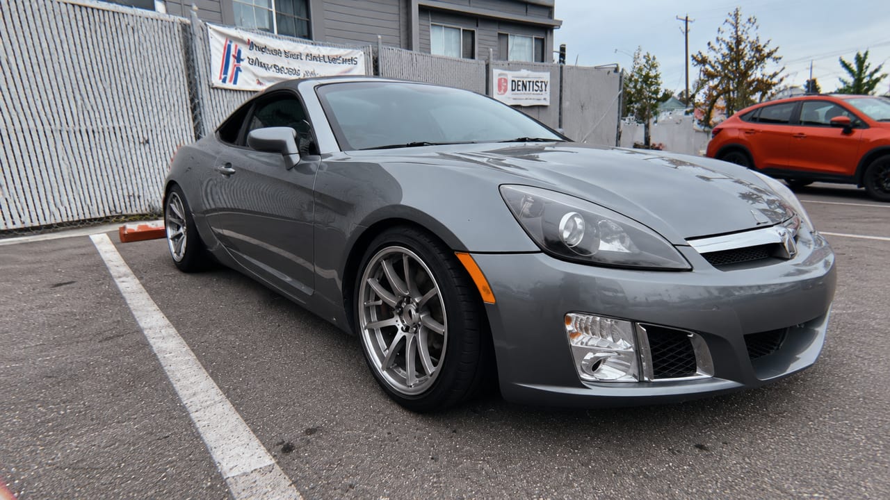 Silver convertible outside the shop — AI-assisted adaptation of owner photo