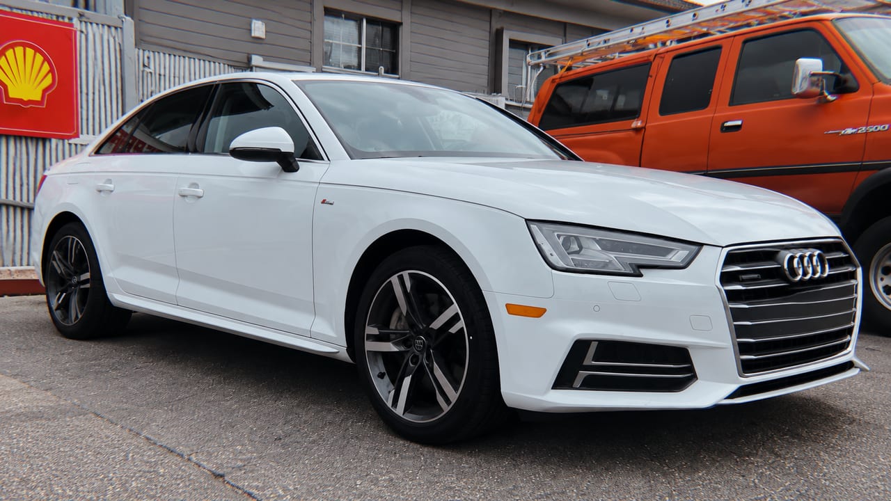 White sedan outside the shop — AI-assisted adaptation of owner photo